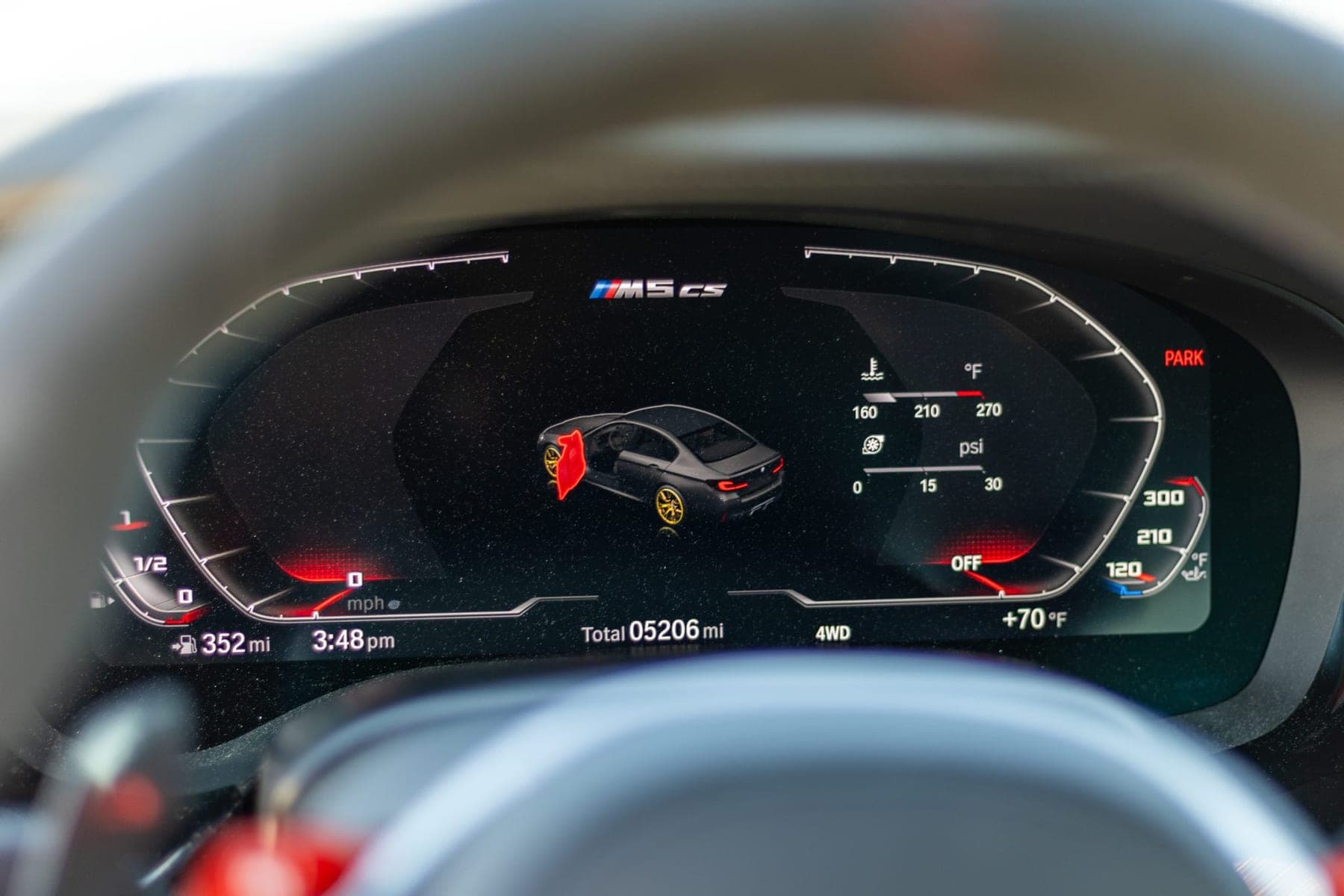 Digital instrument cluster of a BMW M5 CS showing the total odometer reading, fuel level and temperature